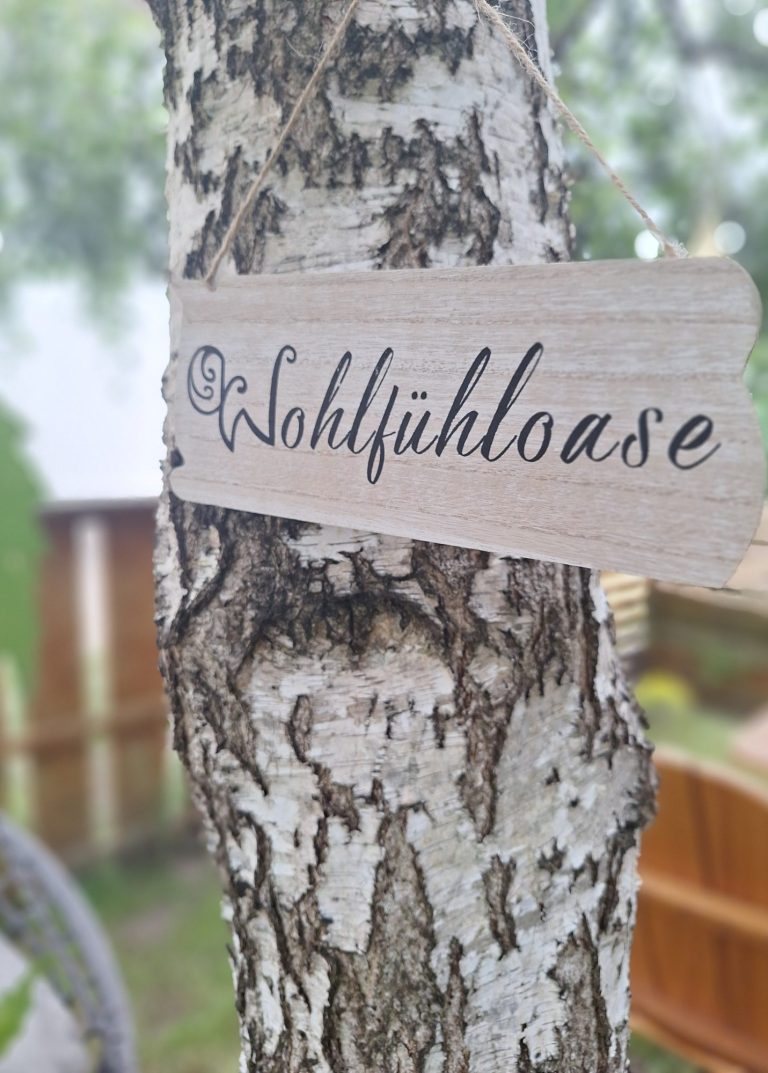 Wohlfühloase Birke mit einem Schild mit dem Titel Wohlfühloase aus meinem Garten.
